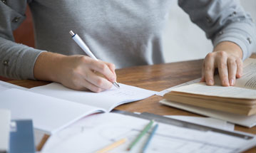 Traveller with suitcase at airport window, representing new journeys and global opportunities with Berlitz.